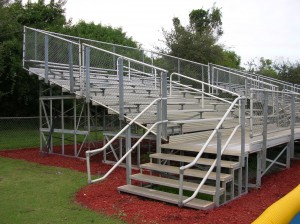 Elevated bleachers with side steps and handrails.