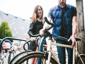 couple locking their bikes to bike parking racks
