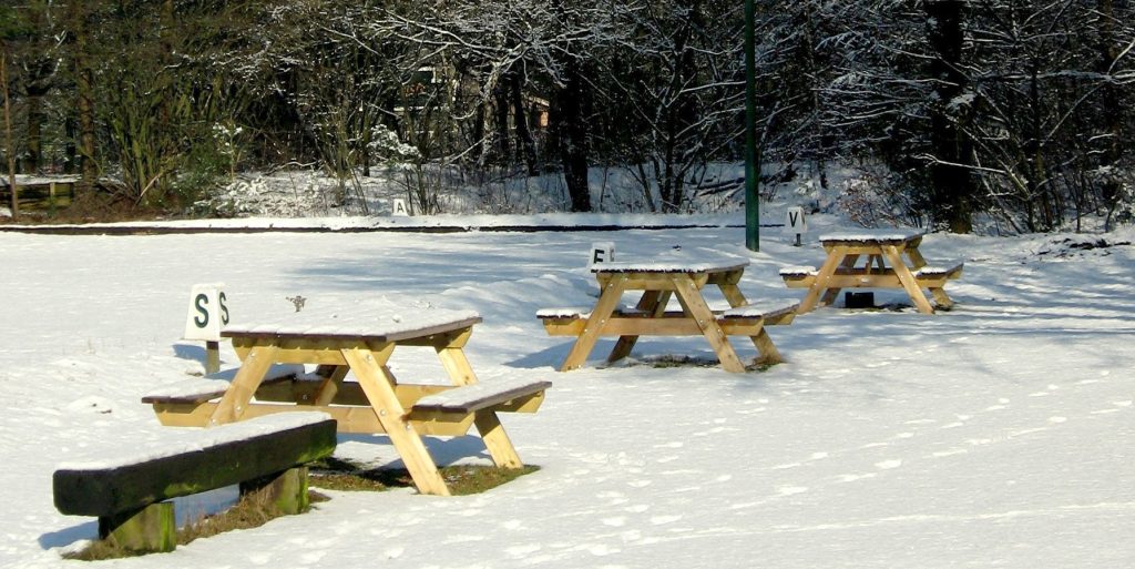 picnic tables along a snowy trail